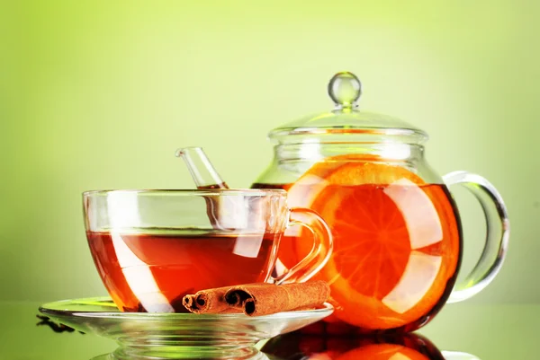 Zwarte exotisch fruit thee in de theepot glas en cup op groene achtergrond — Stockfoto