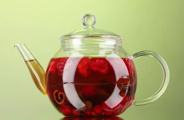 Скляний чайник з фруктовим малиновим чаєм на зеленому фоні — стокове фото