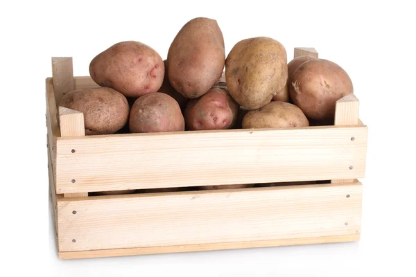 Сырой картофель в деревянной коробке, изолированной на белом — стоковое фото
