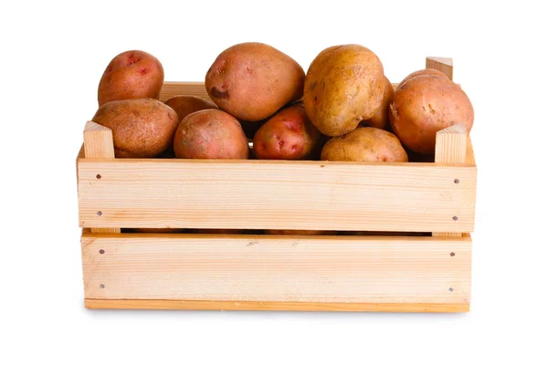 Syrové brambory v dřevěné krabici, izolované na bílém — Stock fotografie