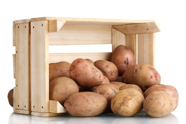 Patatas crudas en una caja de madera aislada en blanco — Foto de Stock