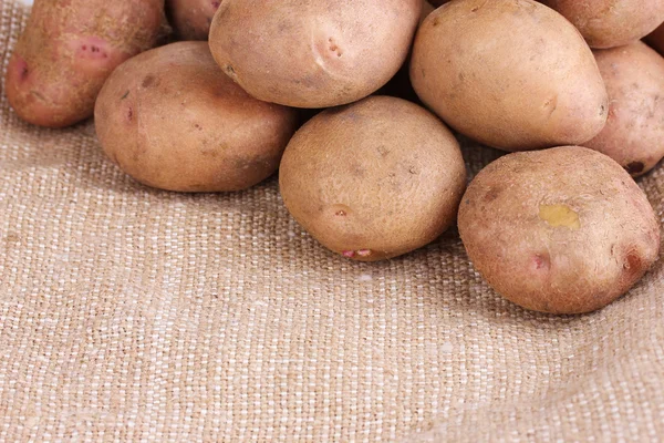 Fresh potatoes on burlap closeup — Stock Photo, Image