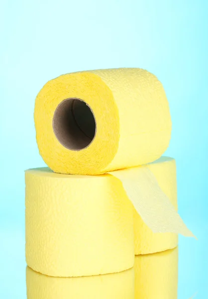 在蓝色背景上黄色卷厕纸 — 图库照片