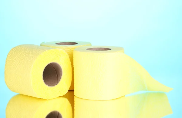 Yellow rolls of toilet paper on blue background — Stock Photo, Image