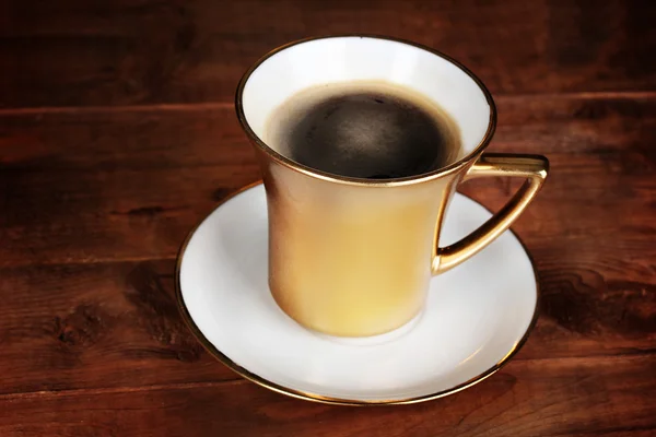 ゴールデン コーヒー カップの木製のテーブル — ストック写真