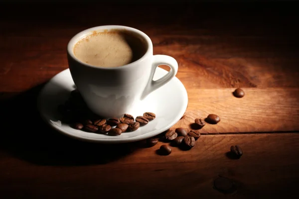 咖啡和咖啡豆在木桌上的杯子 — 图库照片
