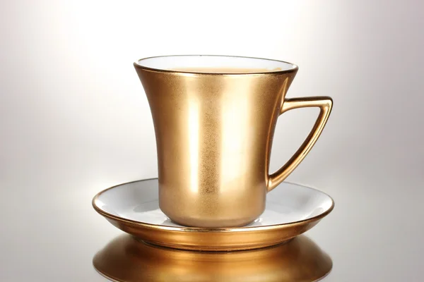 Golden cup of coffee isolated on white — Stock Photo, Image