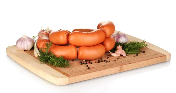 Salsichas saborosas em tábua de madeira e isolamento de especiarias em branco — Fotografia de Stock