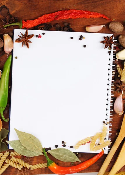 Notebook for recipes and spices on wooden table — Stock Photo, Image