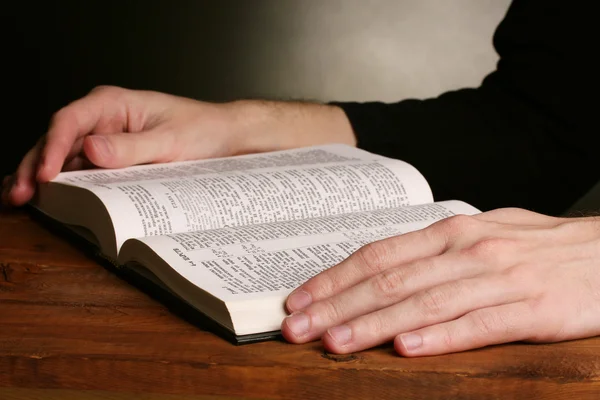 Lesen der offenen russischen Heiligen Bibel auf Holztisch Stockbild