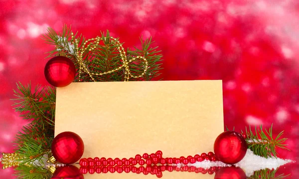 Postal en blanco, bolas de Navidad y abeto sobre fondo rojo Fotos De Stock