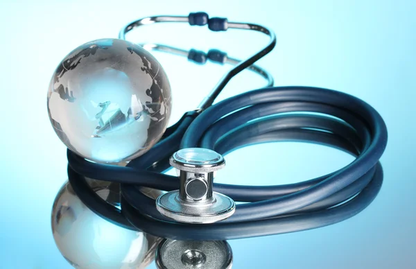 Globe and stethoscope on blue Stock Picture