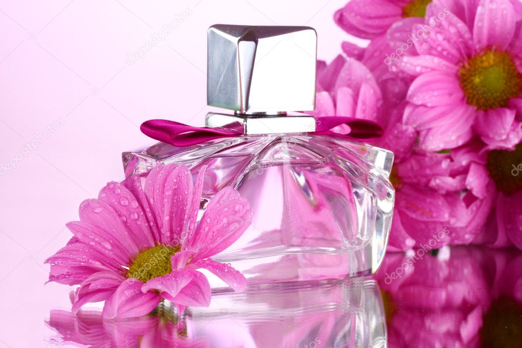 Women's perfume in beautiful bottle and flowers isolated on white