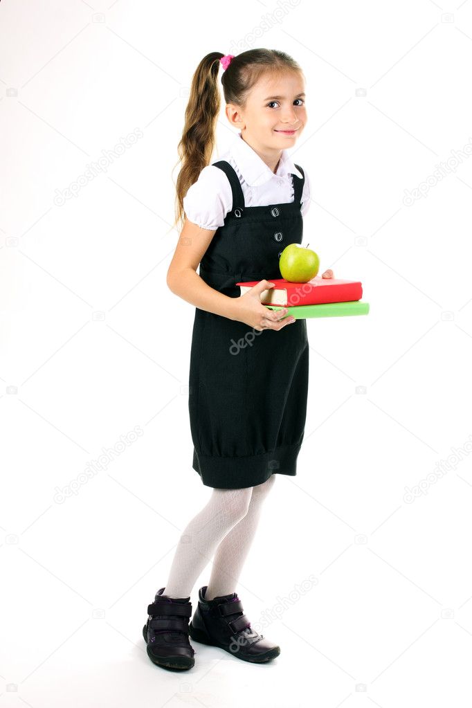 Beautiful little girl in school uniform, books and apple isolated on white