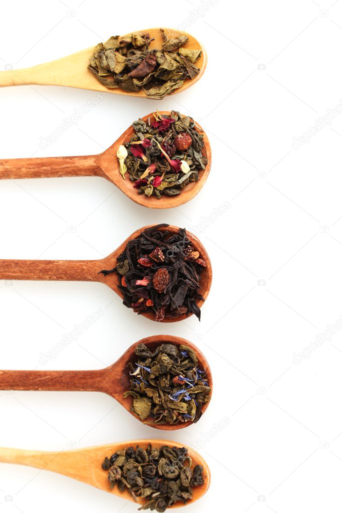 Different kinds of green and black dry tea in woooden spoon isolated on whi
