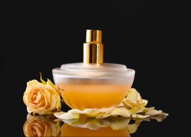 Women's perfume in beautiful bottle with roses on black background clipart