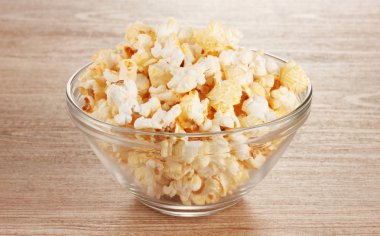 ahşap masa üzerinde cam kase patlamış mısır