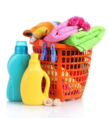 Clothes with detergent in orange plastic basket isolated on white clipart