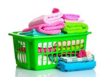 Towels in green plastic basket isolated on white clipart