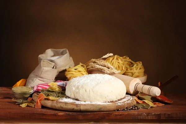 Ingredientes para massas caseiras na mesa de madeira no fundo marrom — Fotografia de Stock