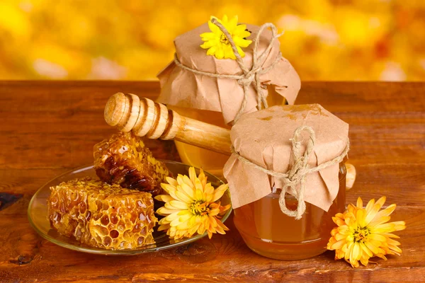 꿀, 넓어짐, 노란색 backgro 테이블에 나무 drizzler의 두 항아리 — 스톡 사진