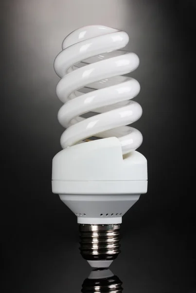 Энергосберегающая лампочка на сером фоне — стоковое фото