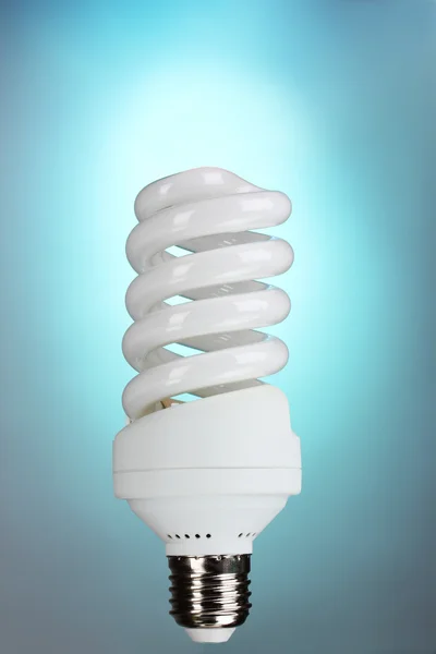 Энергосберегающая лампочка на синем фоне — стоковое фото