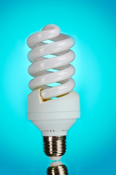 Energy saving light bulb on blue background — Stock Photo, Image