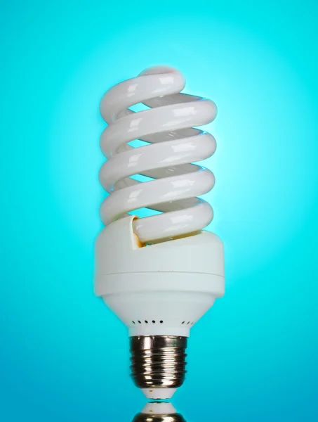 Энергосберегающая лампочка на синем фоне — стоковое фото