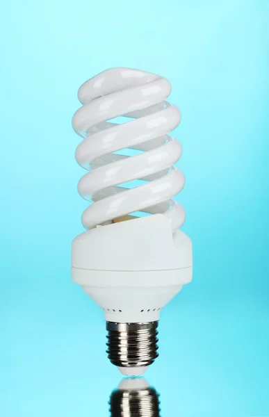 Ampoule à économie d'énergie sur fond bleu — Photo