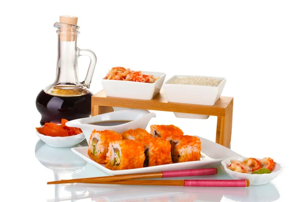 Pyszne sushi na płytkę, pałeczki, sos sojowy, ryby i krewetki na białym tle — Zdjęcie stockowe