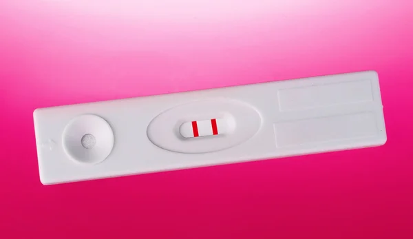Test di gravidanza positivo su sfondo rosa — Foto Stock