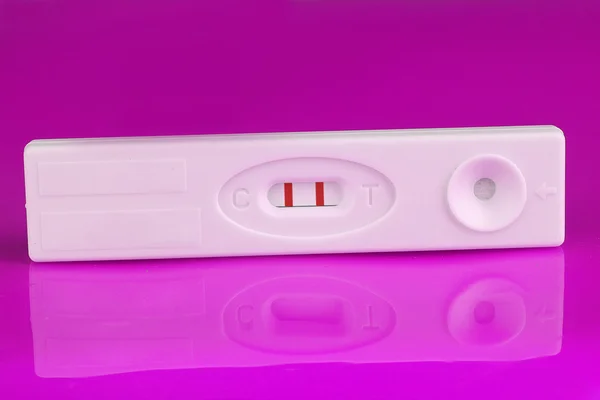 Test di gravidanza positivo su sfondo viola — Foto Stock