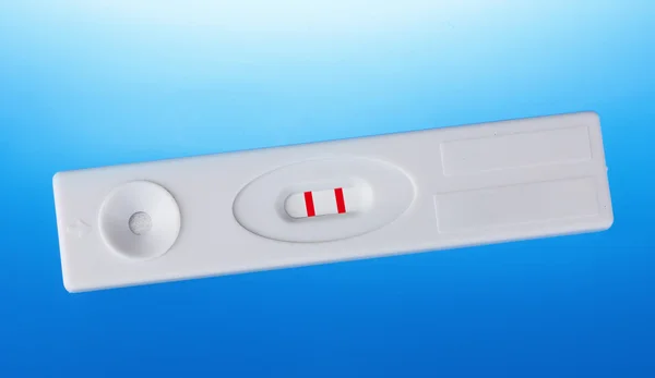 Mavi arka planda pozitif hamilelik testi — Stok fotoğraf