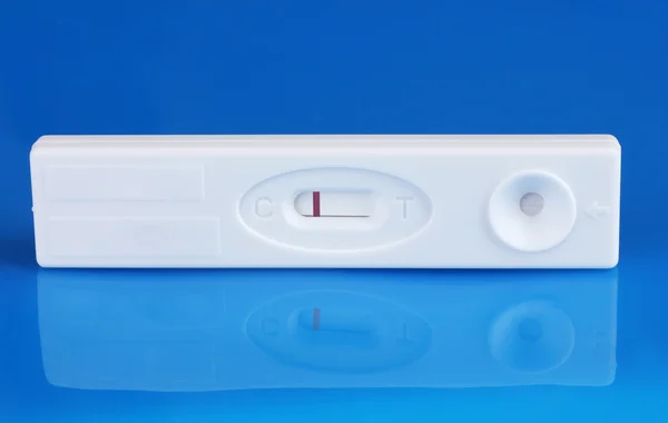 Prueba de embarazo sobre fondo azul — Foto de Stock