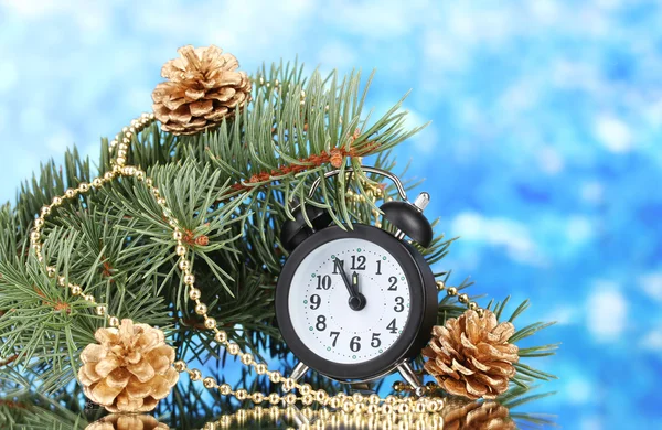 Grön julgran och klockan på blå — Stockfoto