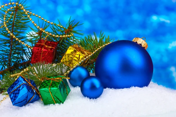Christmas ball and toy with green tree in the snow on blue — Stock Photo, Image