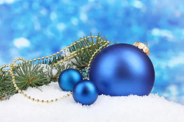 Bola de Natal e árvore verde na neve em azul — Fotografia de Stock