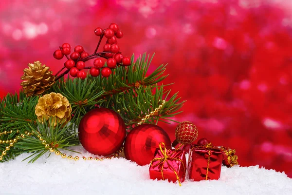 Christmas ball and green tree in the snow on red — Stock Photo, Image