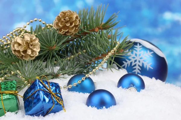 Vánoční koule a zelený strom na sněhu na modré — Stock fotografie