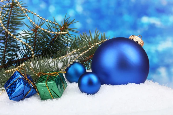 Різдвяний м'яч та іграшка з зеленим деревом у снігу на синьому — стокове фото