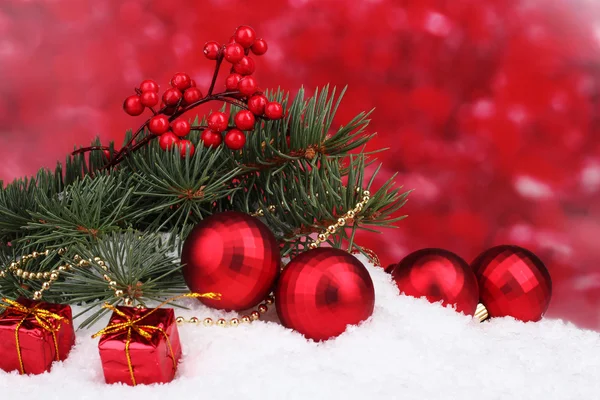 Bola de Natal e brinquedo com árvore verde na neve no vermelho — Fotografia de Stock