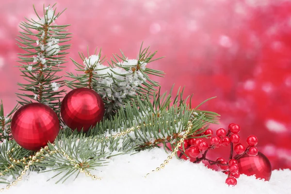 Kerstboom voor bal en groen in de sneeuw op rood — Stockfoto
