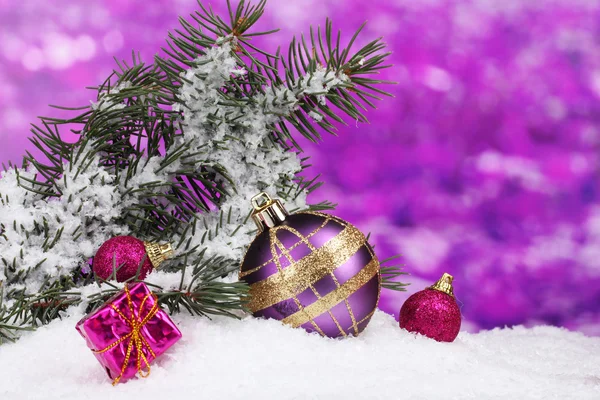 Christmas ball and toy with green tree in the snow on purple — Stock Photo, Image