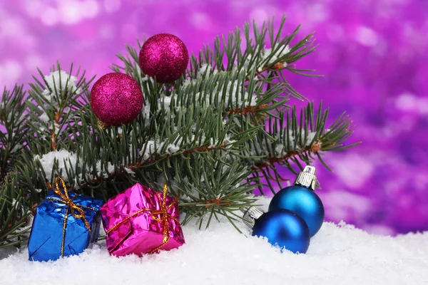 Bola de Navidad y juguete con árbol verde en la nieve en púrpura —  Fotos de Stock