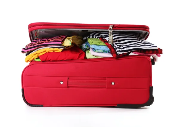 ? losed červený kufr s oblečením izolovaných na bílém — Stock fotografie