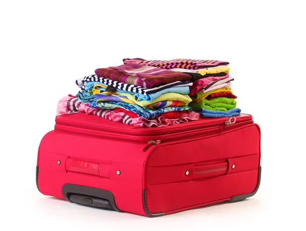 ? losed czerwoną walizkę z ubrania na białym tle — Zdjęcie stockowe