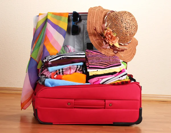 Maleta roja abierta con ropa en la habitación — Foto de Stock