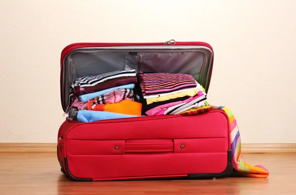 Buka koper merah dengan pakaian di dalam ruangan — Stok Foto