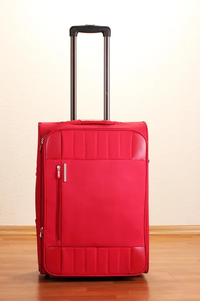 Rode koffer geïsoleerd in de kamer — Stockfoto